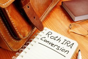 roth ira conversion written on a notepad, do you want to pay taxes in retirement